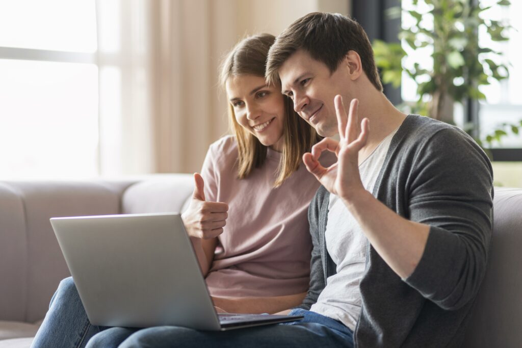 Pareja feliz realizando preaprobación de crédito hipotecario desde su computador