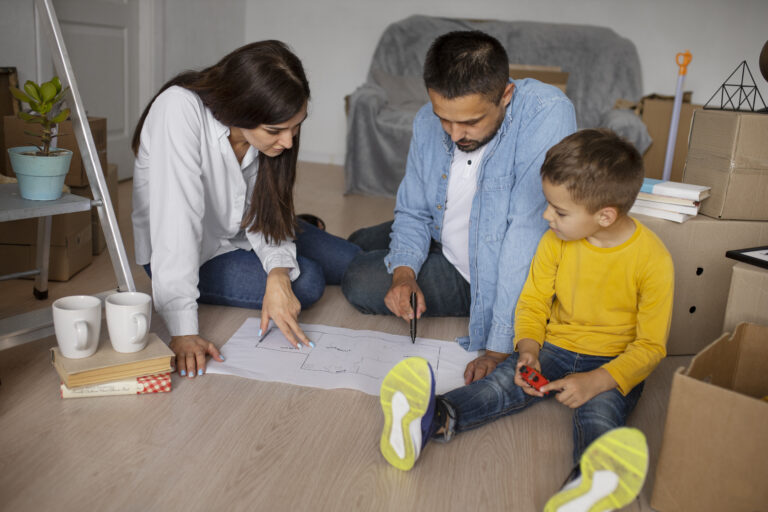 Familia feliz revisando planos de su nueva vivienda tras adjudicarse un subsidio habitacional.