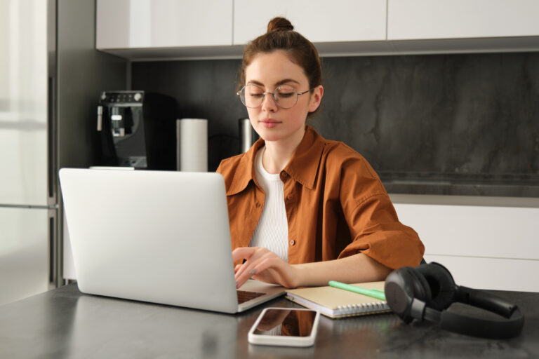 Mujer joven buscando casas en venta con subsidio desde su computador portátil