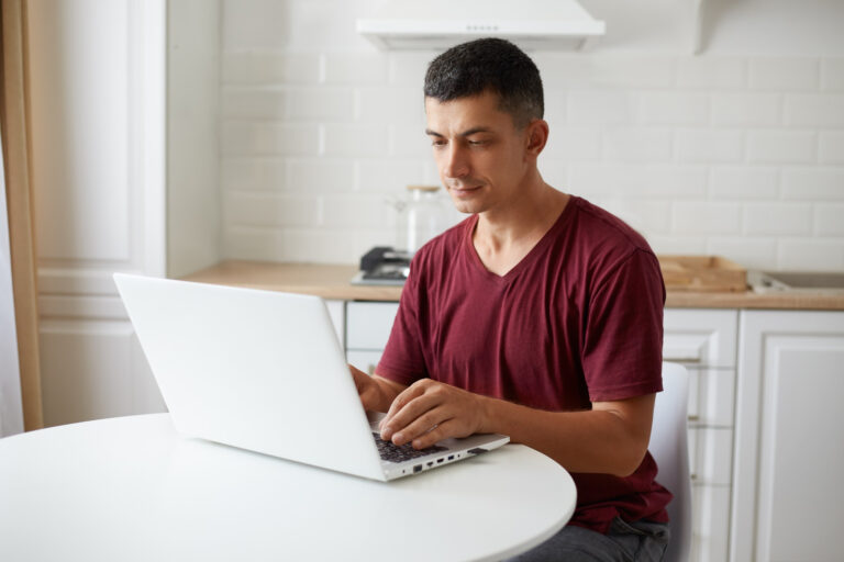 Hombre revisando proyecciones de inversión inmobiliaria en su computador desde casa