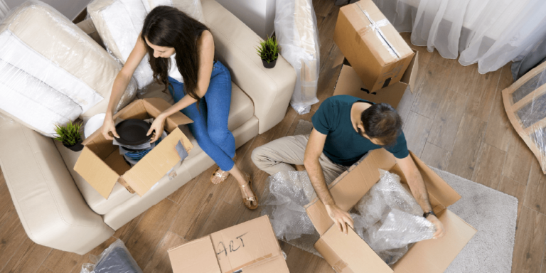 Pareja desempaquetando cajas tras mudanza a nueva vivienda