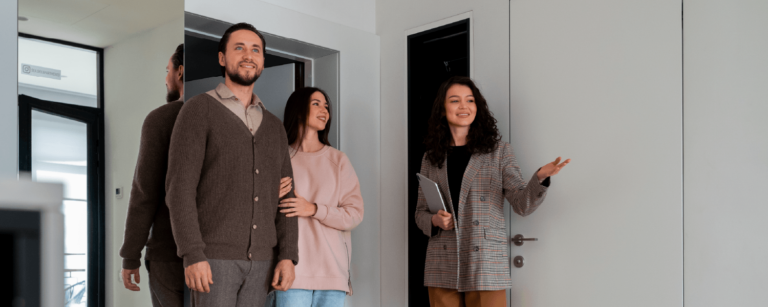 Pareja visitando una propiedad junto a agente inmobiliaria