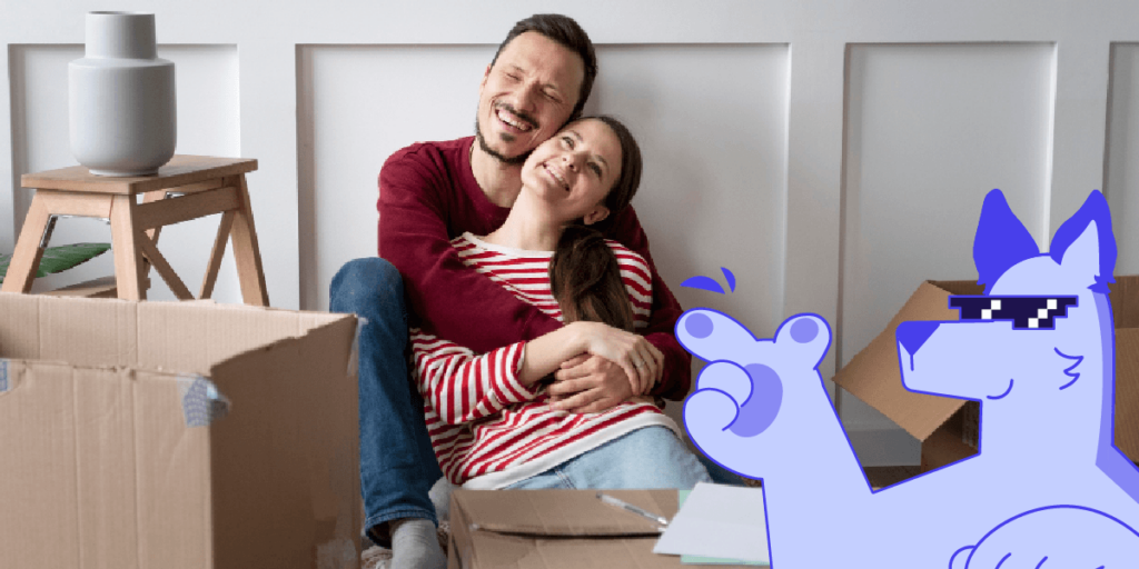 Pareja feliz abrazada entre cajas de mudanza con mascota digital Enlace